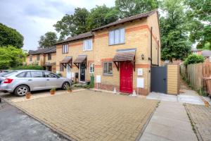 een stenen huis met een rode deur en een auto bij 2 bedroom luxury House in Oxford in Oxford