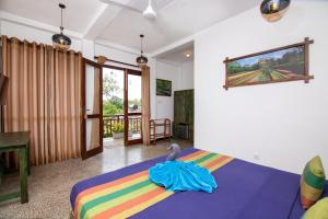 1 dormitorio con 1 cama con una manta colorida en Nature Cabanas & Floating Restaurant en Galle