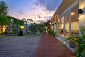 スミニャックにあるThe Daha Luxury Villasの夕日の見える建物外の通路