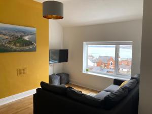 a living room with a couch and a large window at The View Apartments Castle Road in Scarborough
