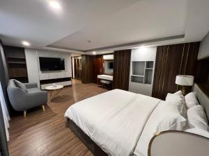 ein Hotelzimmer mit einem großen Bett und einem Stuhl in der Unterkunft Nam Hy 1 Hotel in Ho-Chi-Minh-Stadt