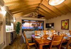 a dining room with a table with wine glasses on it at Villa Moana Maui in Kihei