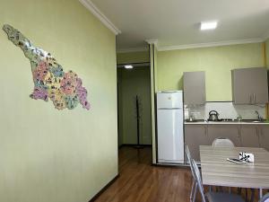um quarto com uma cozinha com uma mesa e um frigorífico em Guest House Demma em Kazbegi