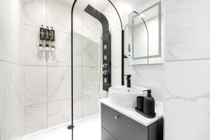 a white bathroom with a shower and a sink at Majestic Luxury Apartment in Marylebone in London