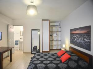 a bedroom with a bed with two red pillows at Résidence Kara Ville in Cayenne