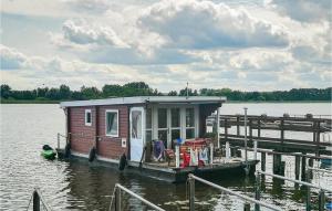 a small house on a dock in the water at Stunning Ship In Brandenburg With Lake View in Kützkow