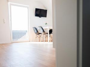 een witte woonkamer met een tafel en stoelen bij Ferienwohnung Kirschbaum in Rust