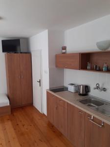 a kitchen with wooden cabinets and a sink at Къща за гости Смокиня in Obzor
