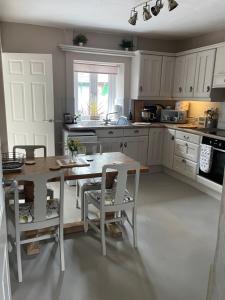a kitchen with a table and some chairs and a table and a table at Pemberton Cottage in Ingleton 