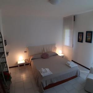 una camera con un grande letto e due lampade di Bonaria Apartment a Cagliari