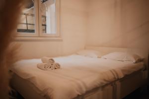 een bed met handdoeken en een raam bij Apartman Tilia in Mostar