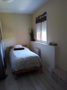 sypialnia z łóżkiem i oknem w obiekcie Maison toulousaine calme- charme-sérénité w mieście Grenade-sur-Garonne