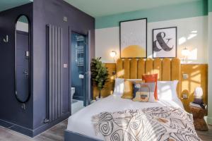 a bedroom with a large bed with colorful pillows at Your Apartment I Brixton in London