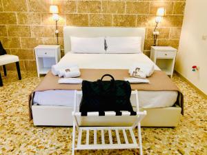 una camera d'albergo con un letto con una borsa nera sopra di Corte Gabellone - dimora storica a Nardò