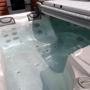uma banheira cheia de água numa casa de banho em Maison toulousaine calme- charme-sérénité em Grenade-sur-Garonne