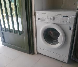 a washing machine in a room next to a door at Villa Kikiriki in Kigali