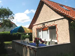 uma casa com uma mesa e cadeiras e um guarda-sol em Ferienhaus Schöne in Lebbin em Groß Teetzleben