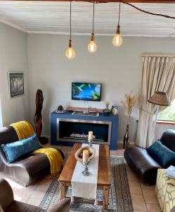 ein Wohnzimmer mit einem Sofa und einem Tisch in der Unterkunft Sandra's Guest House in Langebaan