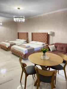 1 dormitorio con 2 camas, mesa y sofá en Tbili Metekhi Boutique Hotel, en Tiflis