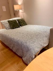 a bed with a comforter on it in a room at Le Casa-blanca Magnifique Appartement chic&cosy in Collobrières