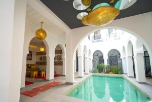 una piscina en una casa con arcos y techo en Riad Shanima SPA Marrakech, en Marrakech