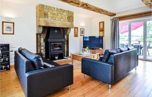sala de estar con 2 sillas de cuero y chimenea en Beautiful Home In Vire Normandie With Lake View 