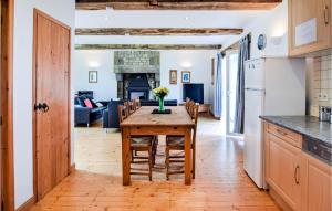 cocina y comedor con mesa de madera y sillas en Beautiful Home In Vire Normandie With Lake View 