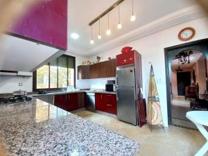 a kitchen with a stainless steel refrigerator and red cabinets at CYCAS VILLA TARGA GARDEN -Only Family in Marrakesh