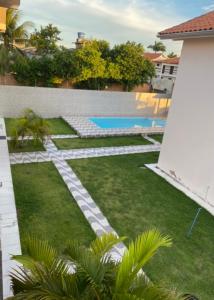 a backyard with a swimming pool and grass at Casa dos Pinheiros Beira-mar in Mutari