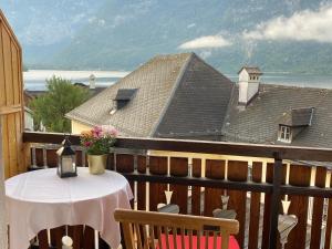 a table and chairs on a balcony with a view at Pension Cafe zum Mühlbach in Hallstatt