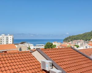 uma cidade com telhados vermelhos e o oceano ao fundo em Cozy studio in Petrovac with sea view em Petrovac na Moru