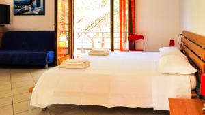 a large white bed with towels on top of it at Villa Verde in Procchio