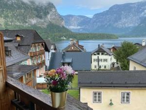 a vase of flowers on a balcony with a view at Pension Cafe zum Mühlbach in Hallstatt