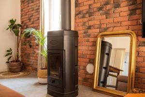 a fireplace with a mirror next to a brick wall at Loft 90 m2 cosy au calme avec terrasse et parking in Avignon