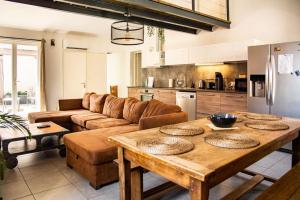 a kitchen and living room with a wooden table at Loft Évasion - Garage & Spa proche du centre historique in Avignon