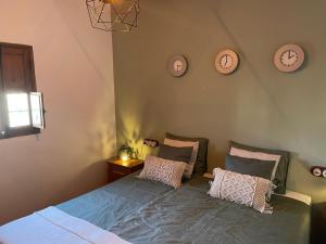 a bedroom with a bed with four clocks on the wall at Casas Demi Dos in Vélez Blanco +15 photos