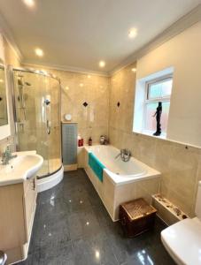 a bathroom with a tub and a shower and a sink at Sunrise in Poole