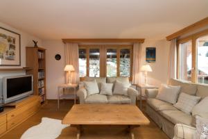 a living room with a couch and a coffee table at Chalet Eigersunne 2 in Wengen
