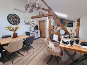eine Küche und ein Esszimmer mit einem Holztisch und Stühlen in der Unterkunft La suite Mélusine - SPA du Souffle du Saule in Buhl-Lorraine