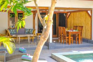 a patio with a table and chairs next to a pool at 3 Angels Villa with Private Pool in Gili Islands