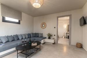 a living room with a blue couch and a table at Golden Sand Villas with Private Pool in Vívlos