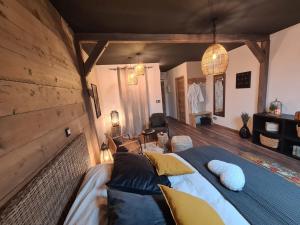 ein Schlafzimmer mit einem großen Bett und einer Holzwand in der Unterkunft La suite Mélusine - SPA du Souffle du Saule in Buhl-Lorraine