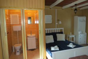 Dormitorio pequeño con cama y aseo en Szitakötő vendégház, en Mártély