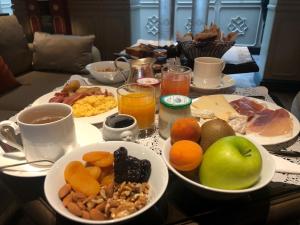 a table topped with plates of breakfast foods and drinks at Hotel de Montesquieu in Paris