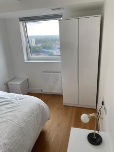 a bedroom with a bed and a large window at Morden 1 bedroom City- Apt Central stylish living in Croydon