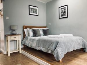 a bedroom with a bed and a night stand with a lamp at Stiwdio Eithinog in Caernarfon