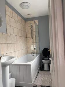 y baño con bañera, aseo y lavamanos. en Cozy 2-bedroom property with shared garden, en Sunderland