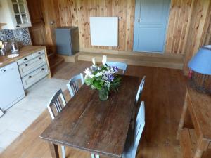 uma cozinha com uma mesa de madeira com um vaso de flores em La Grange de Bois de Chêne em Phalsbourg
