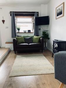 a living room with a couch and a window at Stiwdio Eithinog in Caernarfon