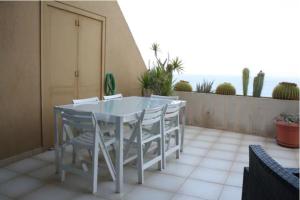 a white table and chairs on a balcony with the ocean at Apartamento frente al mar in Radazul